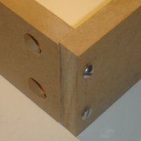 Two pieces of wood joined at a right angle using screws and dross dowels (barrel nuts).